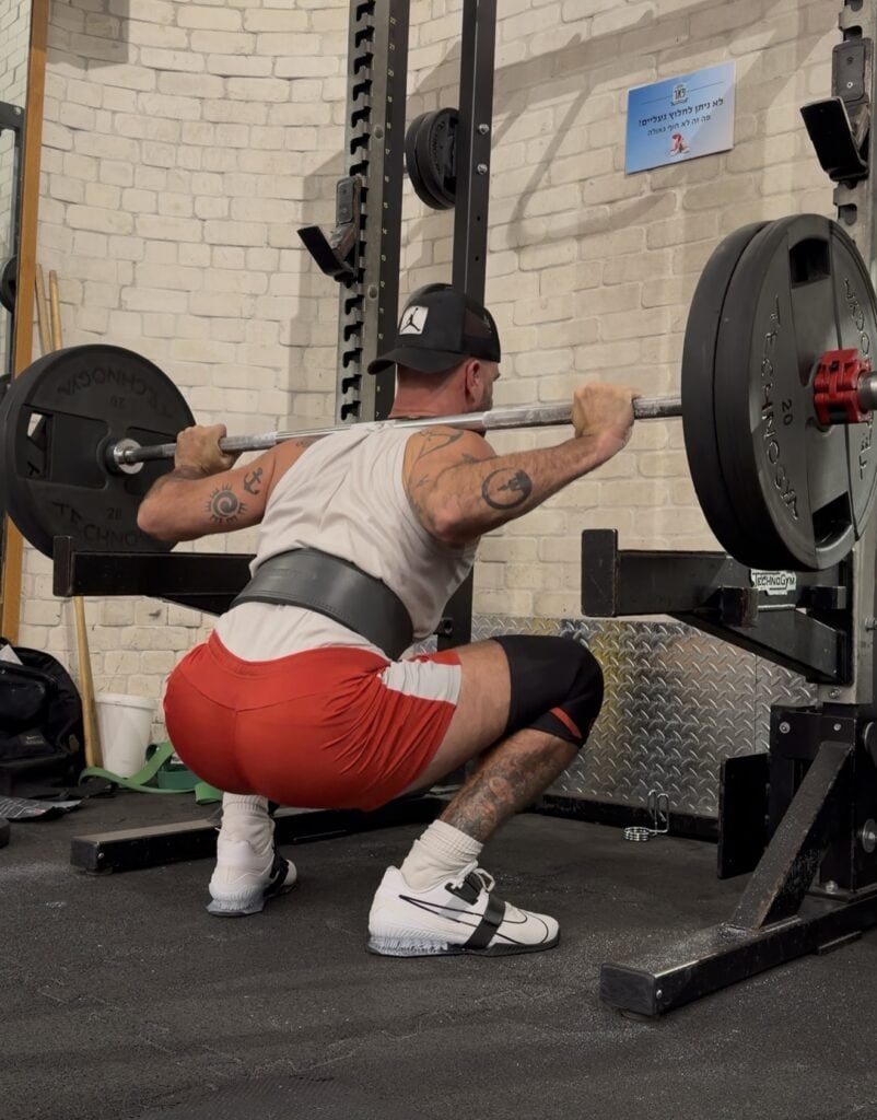 סקוואט עם מוט חופשי באזור הכוח (80–90%) במהלך אימון כוח בסטודיו סטראדל