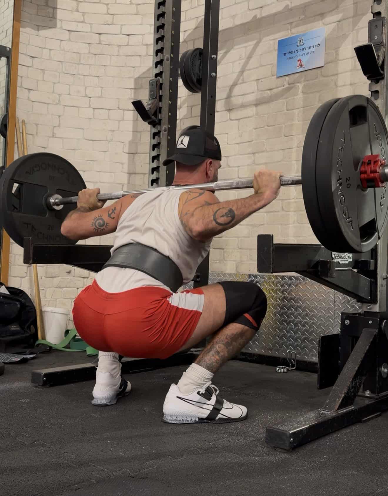 סקוואט עם מוט חופשי באזור הכוח (80–90%) במהלך אימון כוח בסטודיו סטראדל